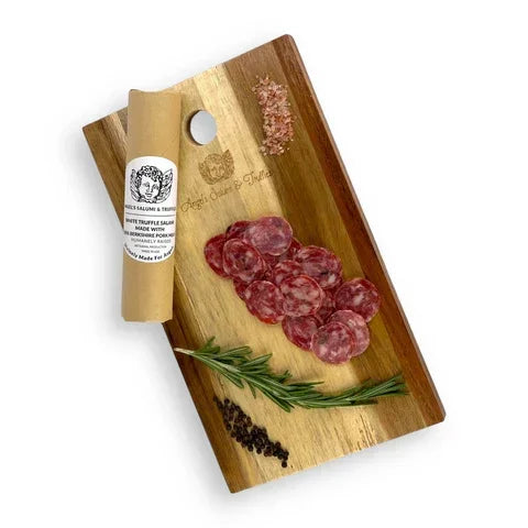 Artisan salami slices with rosemary, peppercorns, and truffle salt on a wooden board