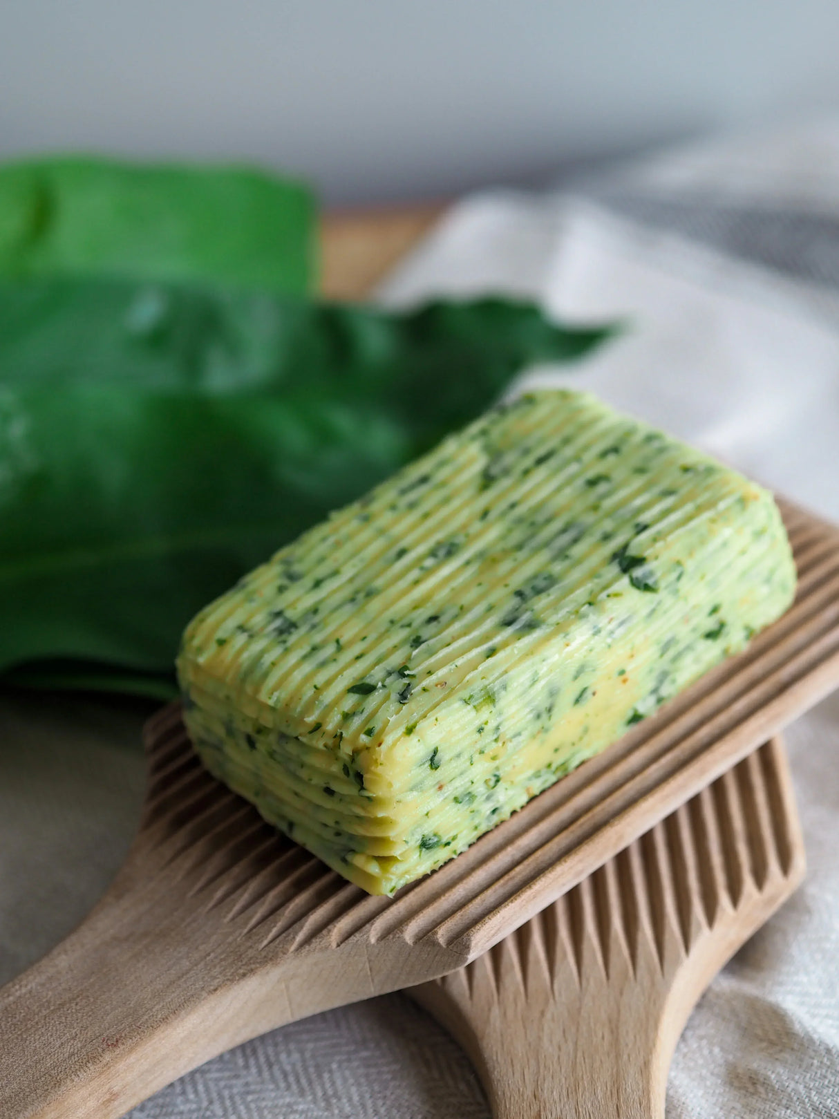 Herb-infused French butter on wooden board, artisan-made, all-natural, premium quality
