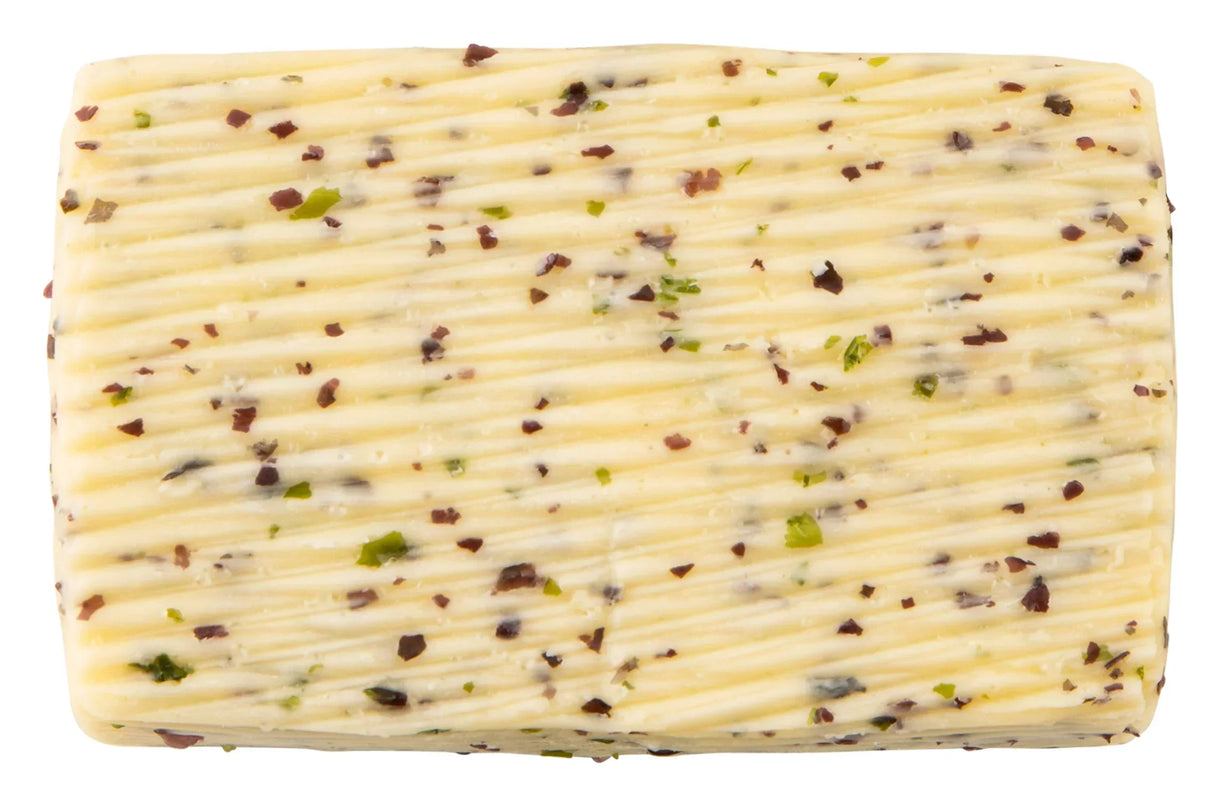 Herb-infused French butter with visible green herbs and red pepper flakes, artisan-made and premium quality.