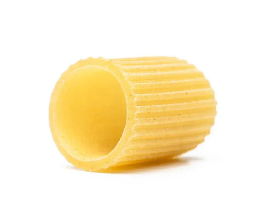 Single ridged mezze maniche pasta tube on a white background, Italian durum wheat semolina pasta