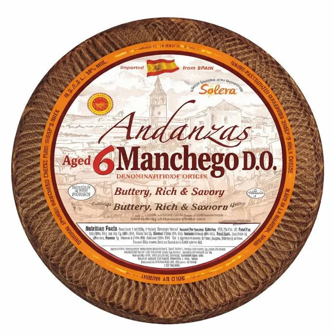 Aged Manchego cheese wheel with rustic rind, labeled as buttery, rich, savory, imported from Spain.