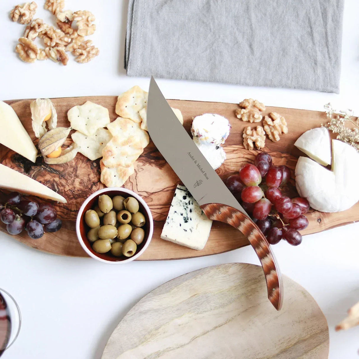 Artisan cheese board with grapes, olives, crackers, and walnuts for gourmet snacking