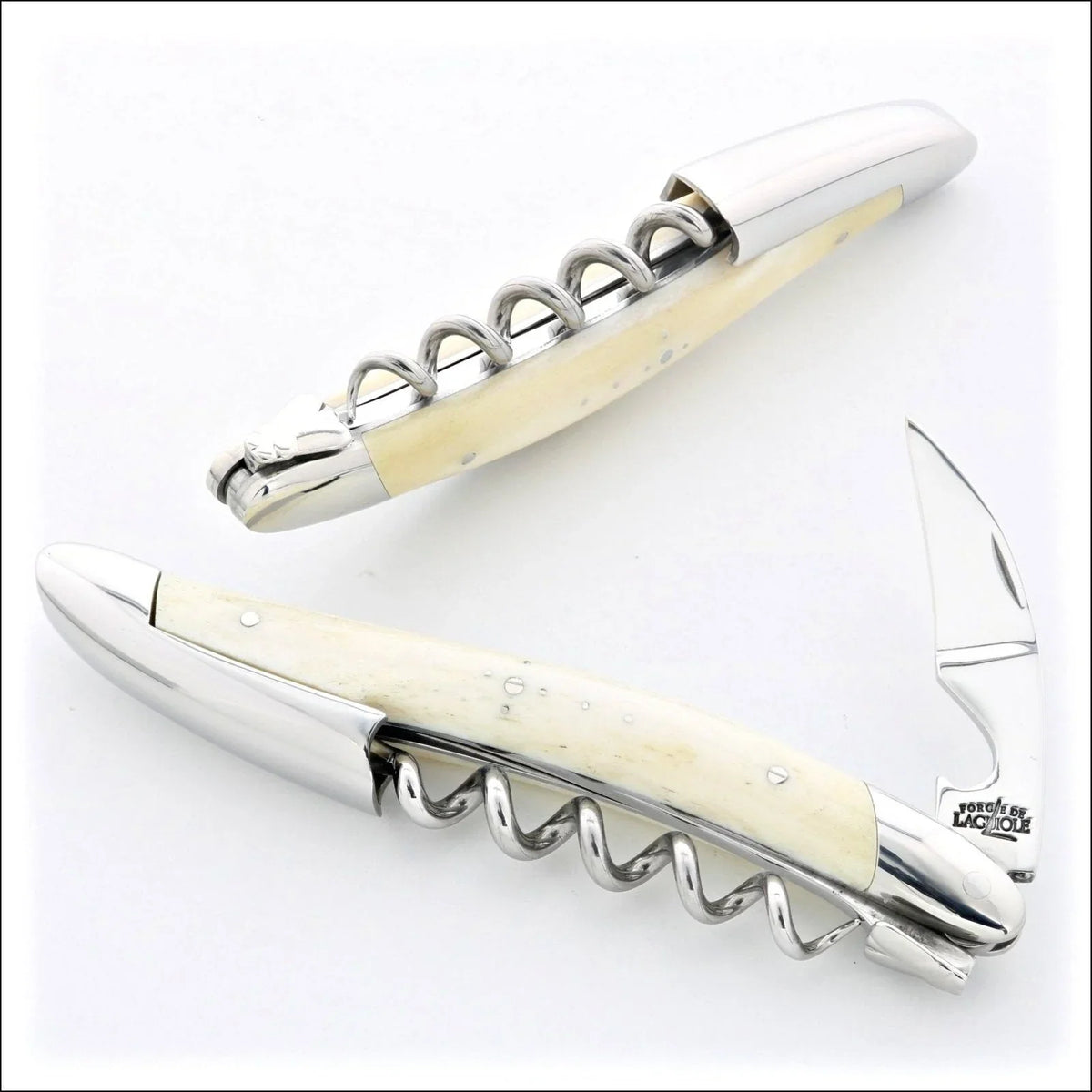 Two Laguiole corkscrews with bone handles, one open showing a silver blade and one closed.
