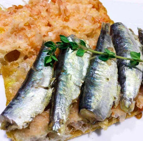 Grilled sardines on artisan bread with fresh thyme, premium French pantry delicacy