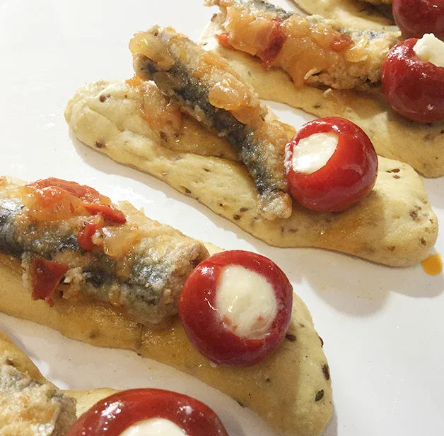 Sardine antipasto on crisp bread with stuffed cherry peppers, gourmet appetizer platter