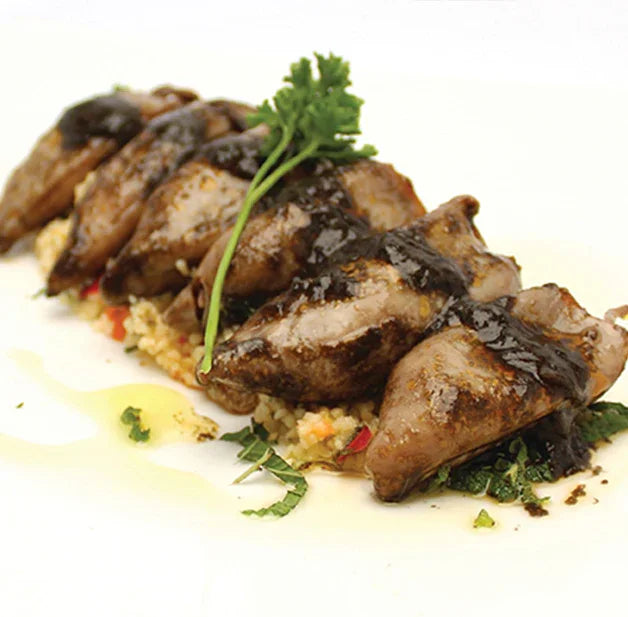 Gourmet French stuffed squid with ink sauce served on couscous, premium artisanal dish