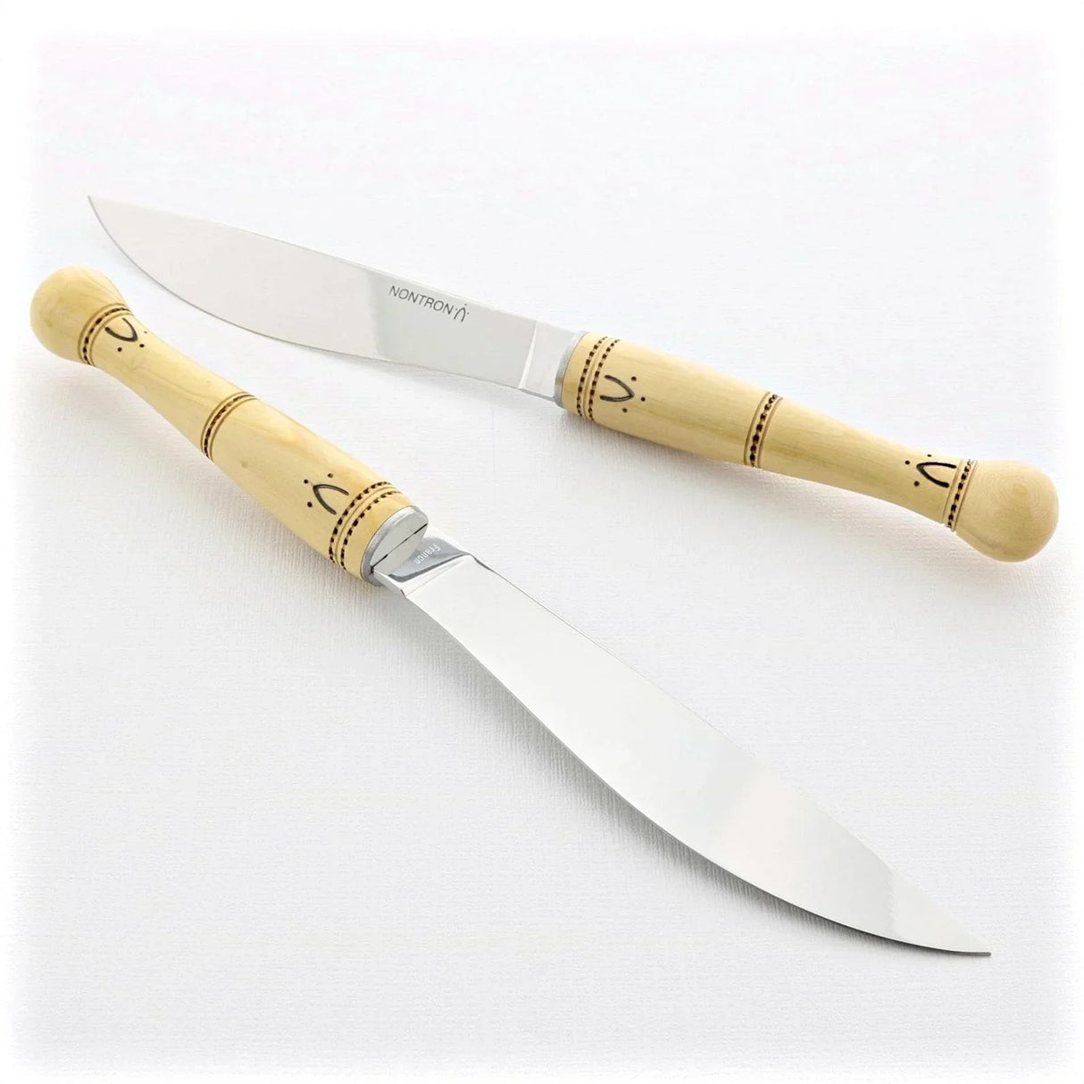 Two French-style kitchen knives with light wood handles and engraved details, artisan-crafted for premium culinary use.