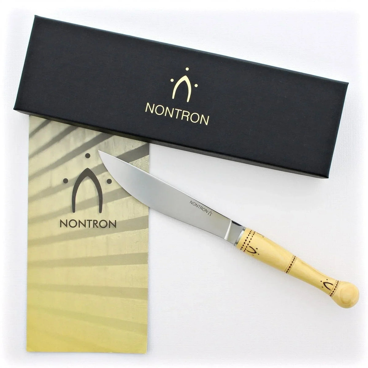 Elegant Nontron knife with wooden handle, displayed beside branded packaging