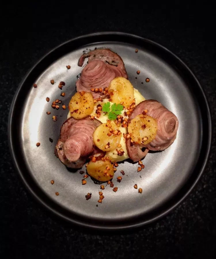 Artisan French dish with roasted potatoes, herbs, and premium meat, elegantly plated for gourmet dining.