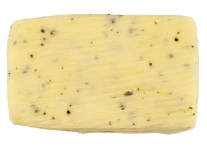 Rectangular block of French truffle butter with visible truffle flecks on white background