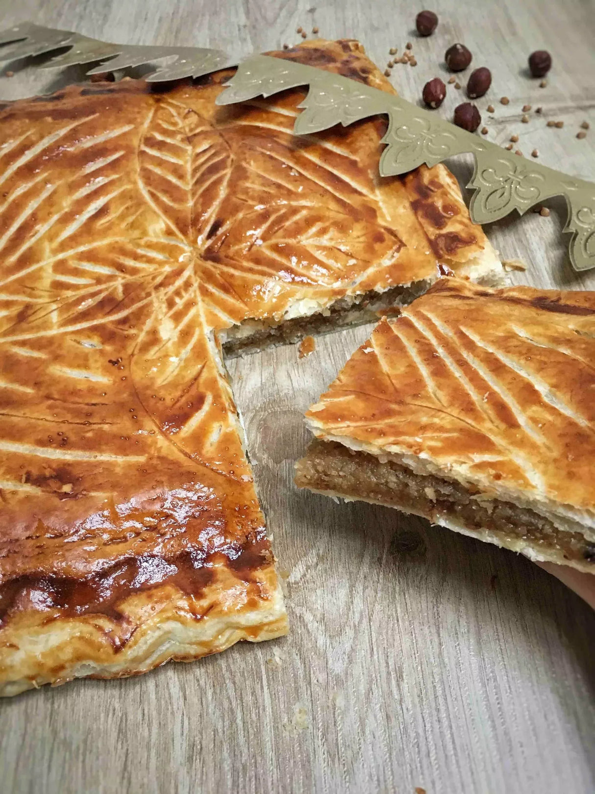 Golden-brown French pastry with leaf design, flaky layers, and nutty filling, artisan-made and premium quality.