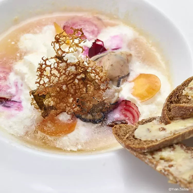Creamy French soup with artisan cheese, crispy garnish, and buttered bread slices