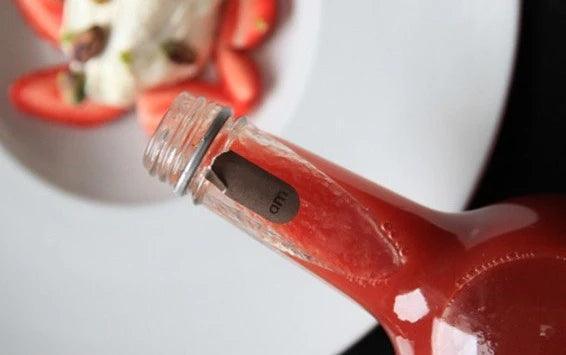 Red sauce bottle pouring over fresh strawberries and cream, artisan-made, gluten-free, keto-friendly