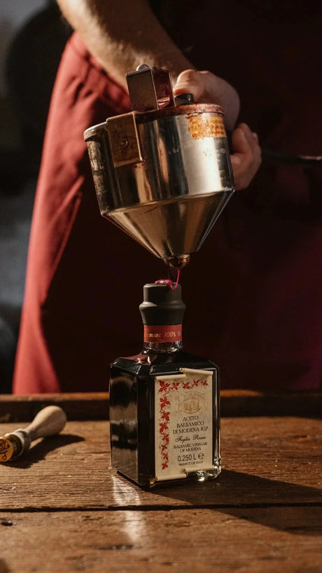 Artisan balsamic vinegar of Modena being poured into a bottle, premium Italian condiment