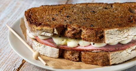 Black truffle croque-monsieur on country bread, cut open to show bechamel and melted cheese