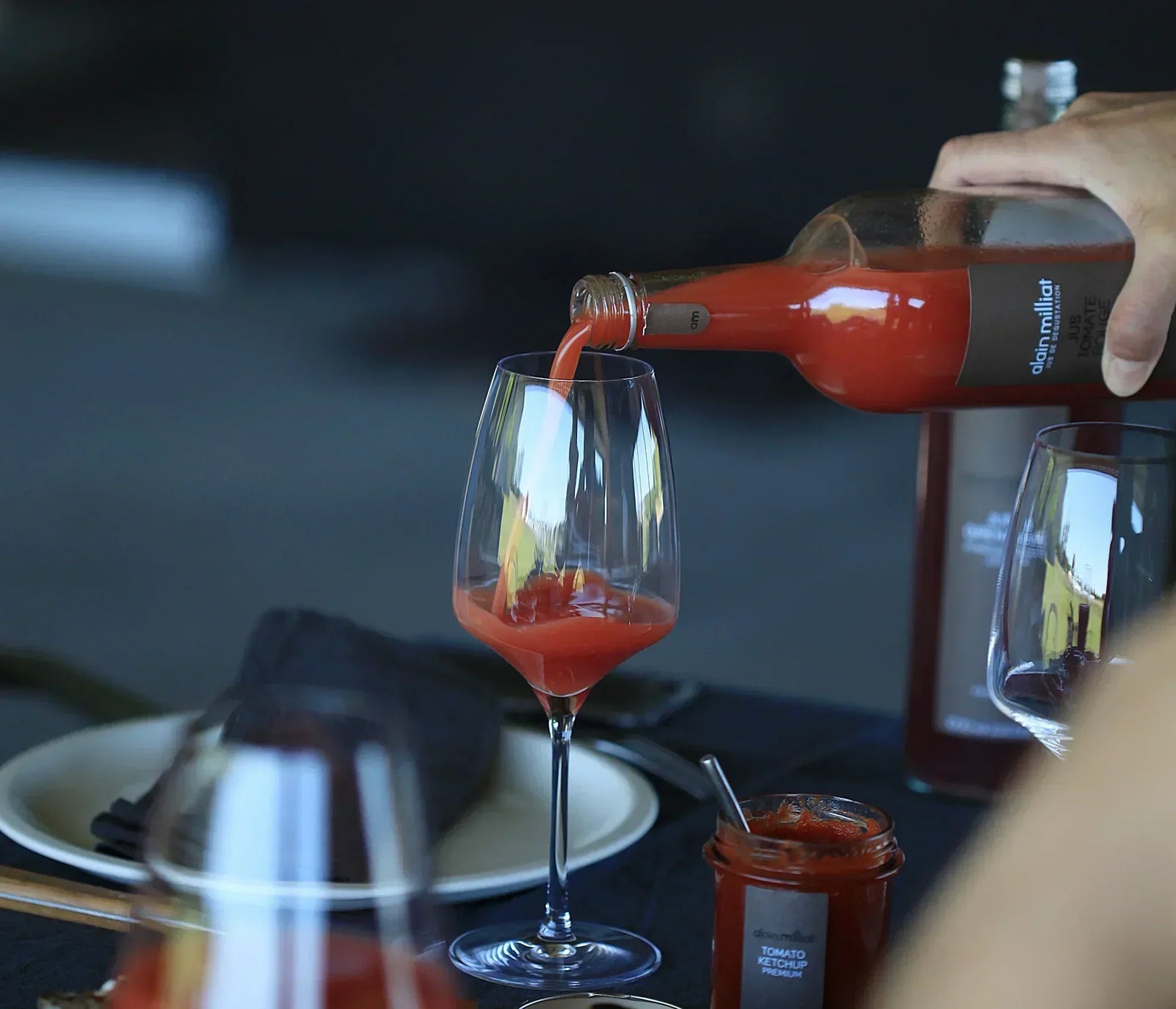 Pouring premium French tomato juice into a wine glass, artisan-made, all-natural, gluten-free