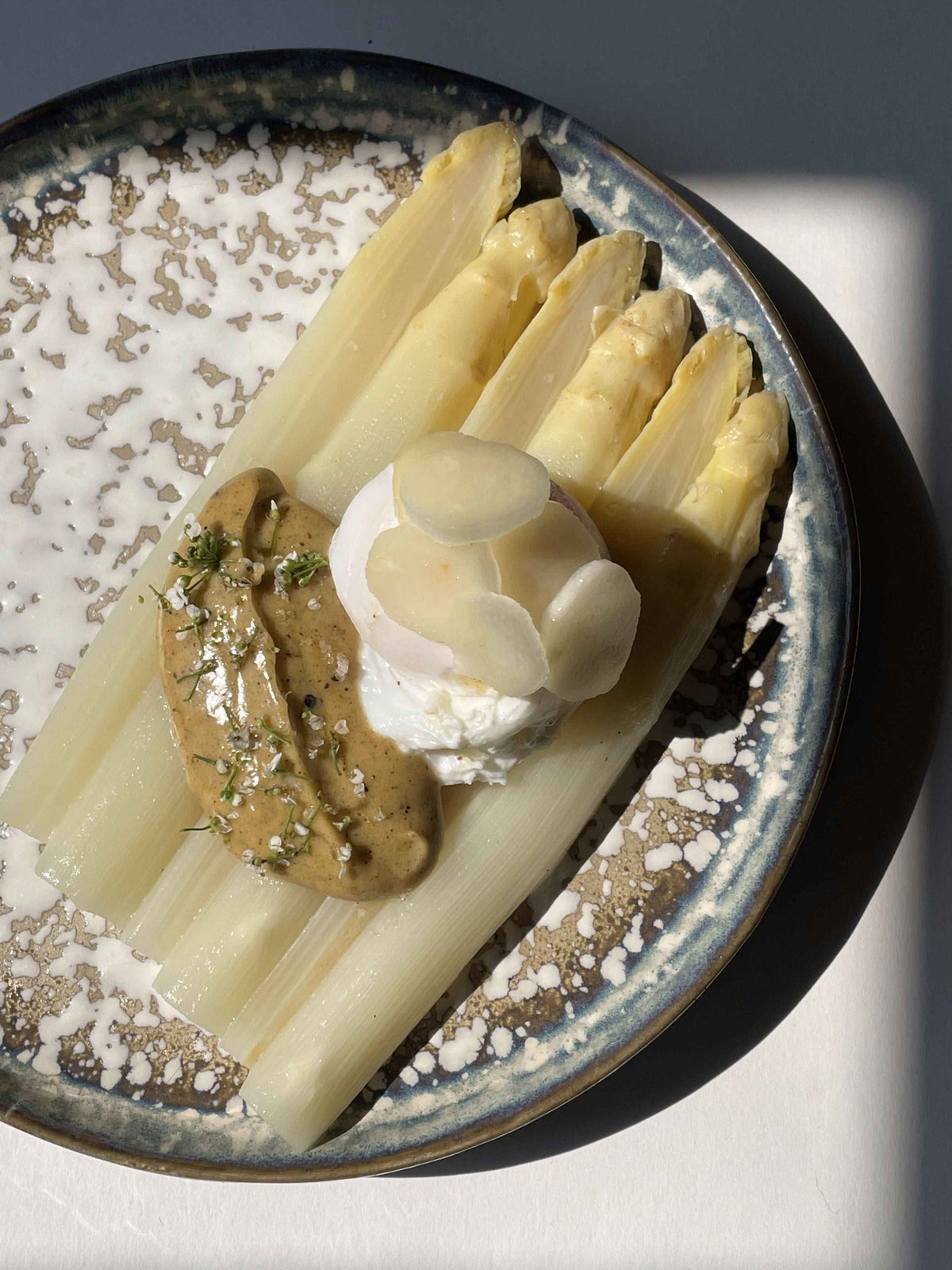 White asparagus topped with a poached egg and vanilla butter hollandaise sauce