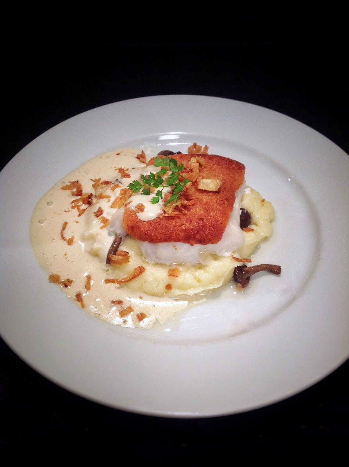 Cod fillet under a parmesan and Roscoff onion butter crust, plated with parsnip mash and onion butter foam