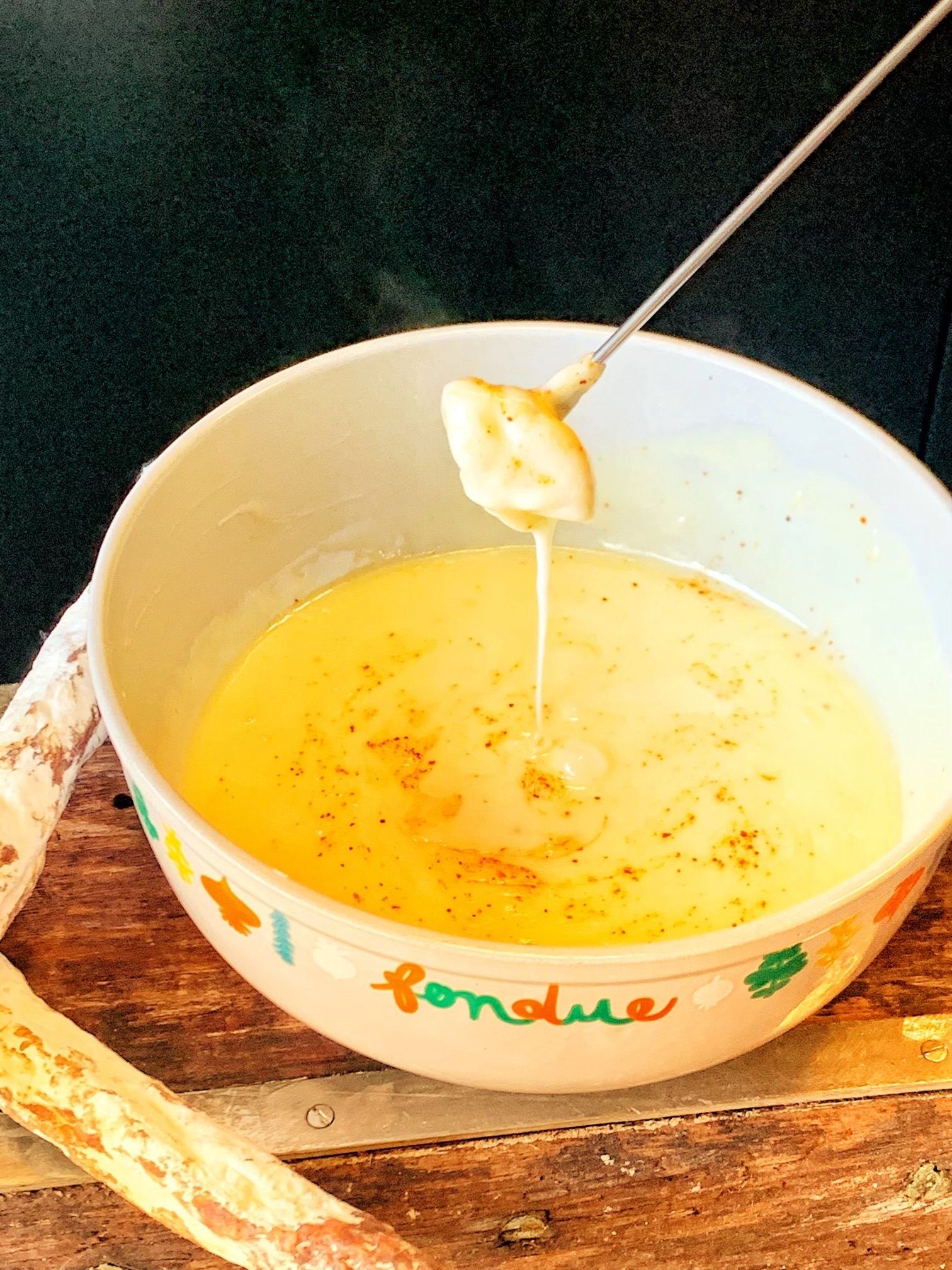 A caquelon of Savoyard cheese fondue with cubes of stale white bread on forks