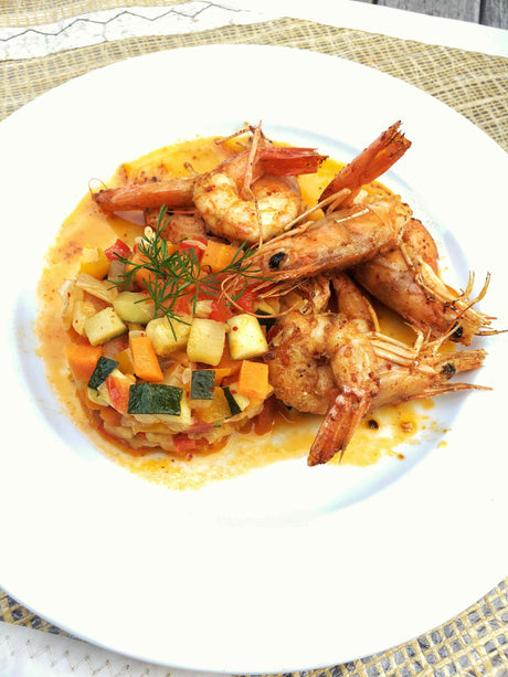 Griddled king prawns in Espelette pepper butter served over finely diced ratatouille
