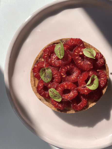 Tartlets filled with raspberry butter lemon cream and topped with fresh raspberries