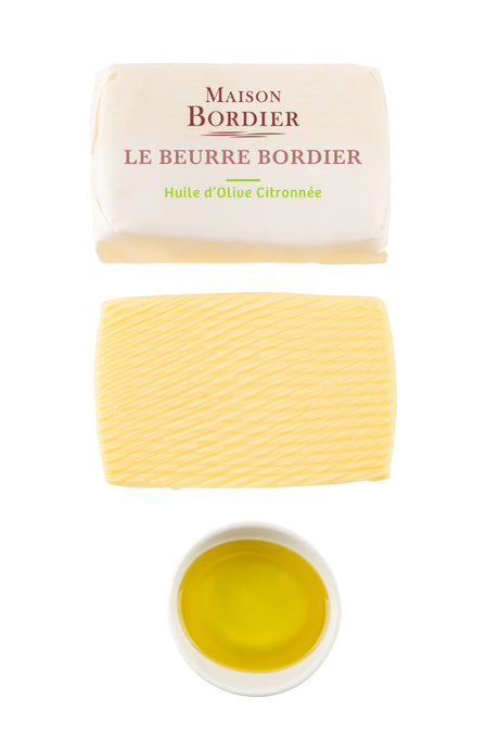 Maison Bordier French butter with lemon olive oil, unwrapped and in a white bowl.