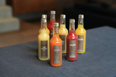 Assorted Alain Milliat French fruit juices and nectars in glass bottles on a table