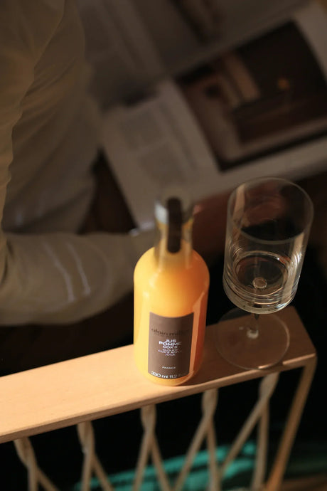 French artisan apple juice bottle and glass on wooden railing, premium gourmet beverage