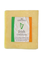 Block of Somerdale Irish Cheddar cheese with green and orange label, creamy texture visible.