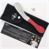 Forge de Laguiole cheese knife with a red handle and black protective pouch.