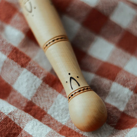 Nontron butter knife wood handle with French carving on a red checkered cloth