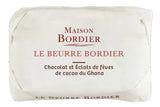 Three stacked product shots on a white background: a wrapped Maison Bordier chocolate bar at the top, an unwrapped rectangular bar of chocolate in the middle, and several dark cocoa beans with cocoa powder at the bottom.