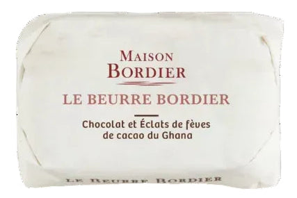 Three stacked product shots on a white background: a wrapped Maison Bordier chocolate bar at the top, an unwrapped rectangular bar of chocolate in the middle, and several dark cocoa beans with cocoa powder at the bottom.