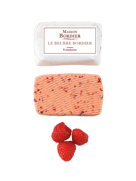 French raspberry butter log, packaging, and fresh raspberries on white background