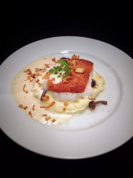 Parmesan-crusted cod on creamy mashed potatoes with butter sauce and crispy onions, French Pantry premium dish
