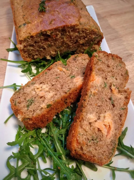 Buckwheat loaf cake with smoked trout and herbs on arugula, French artisan bread