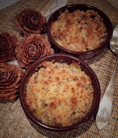 French fruit crumble in brown ramekins with golden crumb topping on rustic table