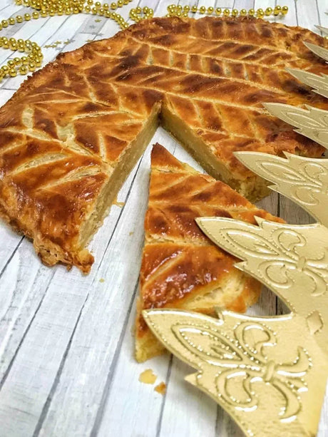 French galette des rois almond cake with golden paper crown on rustic wood table