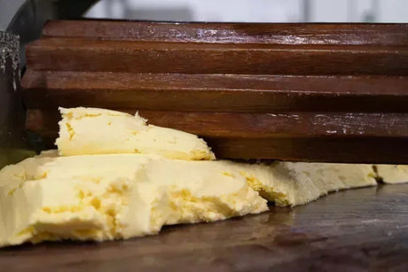 Artisan French butter being kneaded with wooden paddles on a work surface