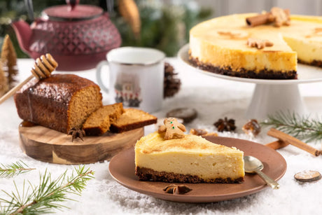 French cheesecake slice and honey gingerbread loaf on festive table with teapot and mug