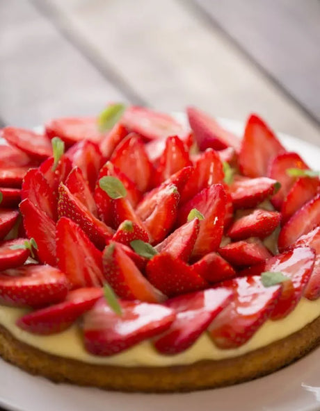 French strawberry tart with fresh sliced strawberries and creamy filling on a white plate