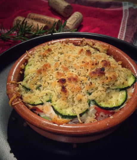 French tian of salmon and vegetables with herb crust in rustic ceramic dish